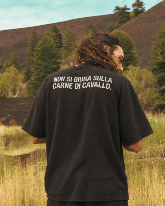 T-shirt KAVALLO nera indossata di spalle, con la frase Non si giura sulla carne di cavallo